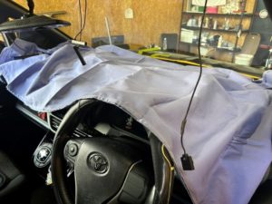 フロントガラスを外すためにダッシュボードを養生している画像